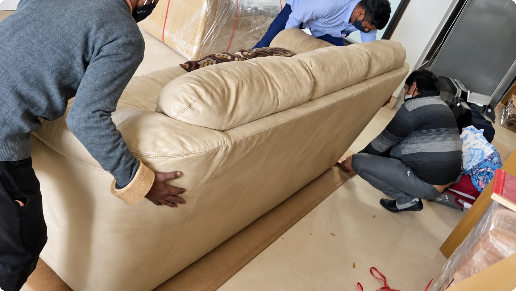 Carefully wrapped furniture being moved through a home